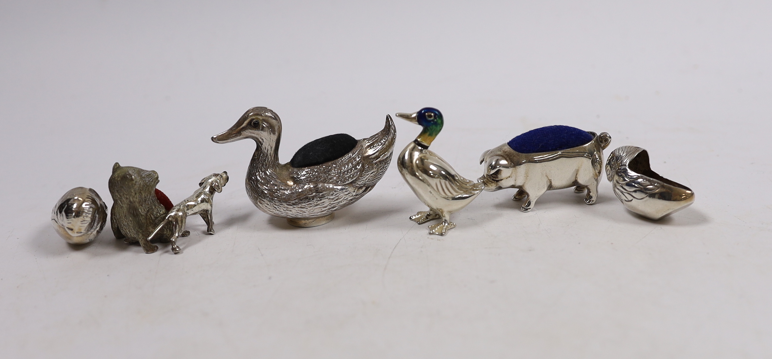Five assorted modern silver mounted novelty pin cushions, including duck, pig and hatching chicks(lacking cushions), together with a silver and enamelled model of a duck, small silver compact and a small model dog.